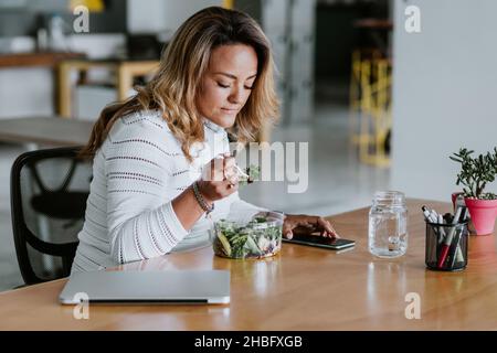 https://l450v.alamy.com/450v/2hbfxgb/latin-adult-woman-eating-salad-lunch-at-the-office-in-mexico-latin-america-2hbfxgb.jpg