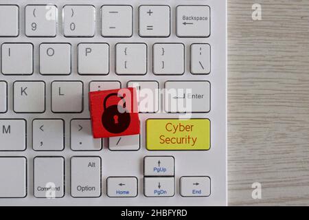 Cyber security concept. Red wooden cube with padlock icon on keyboard with text Cyber Security. Stock Photo