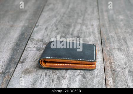 Black leather bifold money and card wallet on wood crafts working Stock Photo