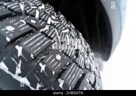 Car tire in the snow close up. Car tracks on the snow. Traces of the car in the snow. Winter tires. Tyres covered with snow at winter road. Winter roa Stock Photo