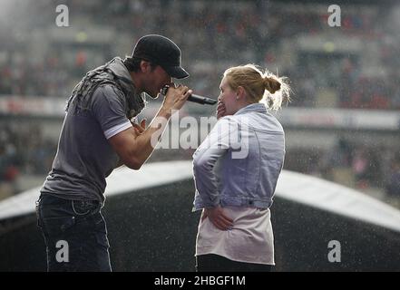 Enrique Iglesias with fan Sophie Elphick on stage during Capital FM's Summertime Ball at Wembley Stadium, London. Stock Photo