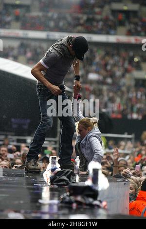 Enrique Iglesias with fan Sophie Elphick on stage during Capital FM's Summertime Ball at Wembley Stadium, London. Stock Photo