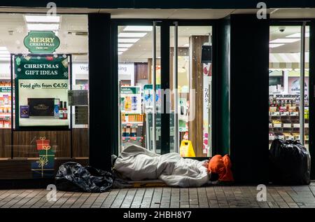 Cork City, Cork, Ireland. 20th December, 2021. - Homeless person sleeping rough in a shop doorway on Christmas week in Patrick Street, Cork, Ireland. -Credit; David Creedon / Alamy Live News