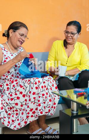 Mature Latin women knitting at home Stock Photo