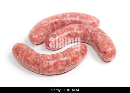 Three crude sausages with mushrooms on a white background Stock Photo