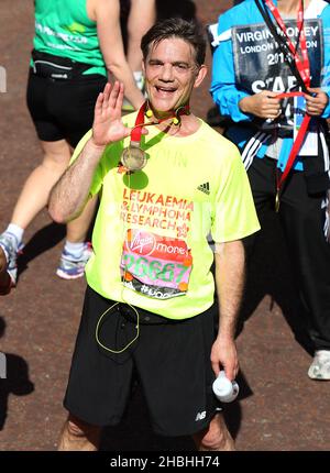 John Michie aka Carl Munro Coronation Street and Holby City Actor with medal at the finishing line of the Virgin Money London Marathon on the Mall in London. Stock Photo