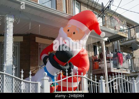 Christmas Decorations. Santa & friends peer out from a porch on a residential street in Corona, Queens, New York City. Stock Photo
