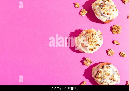 Beautiful fresh cinnamon rolls close-up on pink paper background hard shadow Stock Photo