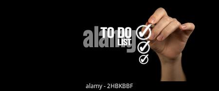 To do list with checklist boxes. Hand marking with pen on a black background, banner Stock Photo