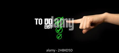 To do list concept. Checklist boxes with green marking on a black background with woman hand, banner Stock Photo