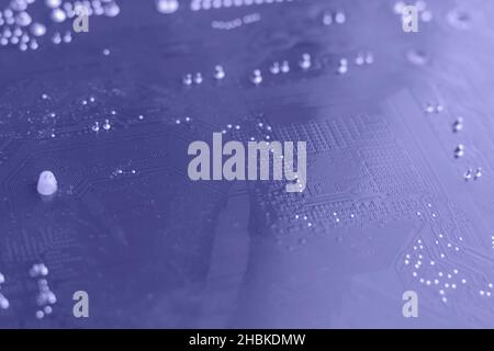 Defocused trendy very peri color concept of the year 2022, violet blue, lavender computer motherboard closeup background. Selective focus Stock Photo