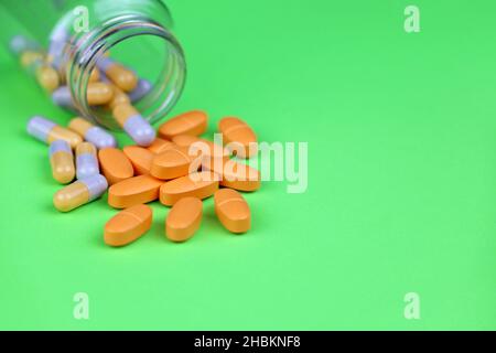 Pills on green background, bottle of different medication in capsules. Concept of nutritional supplements, vitamins, antidepressants Stock Photo