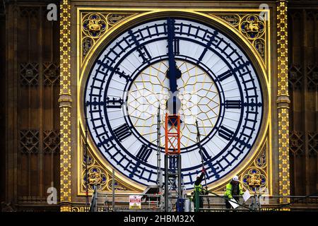 Construction workers remove the scaffolding from the restored west dial of the clock on Elizabeth Tower, known as Big Ben, at the Palace of Westminster. Picture date: Monday December 20, 2021. Stock Photo