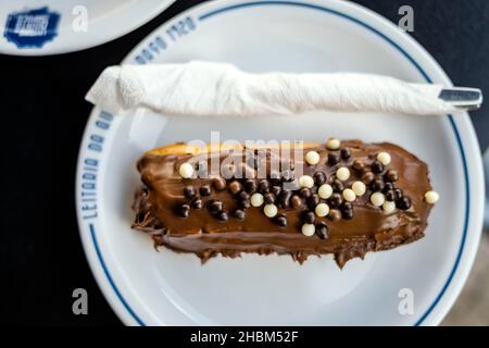 Porto, Portugal - September 25, 2021: Tasty eclair pastry filled and covered  with chocolate in Leitaria  da Quinta do paço Stock Photo