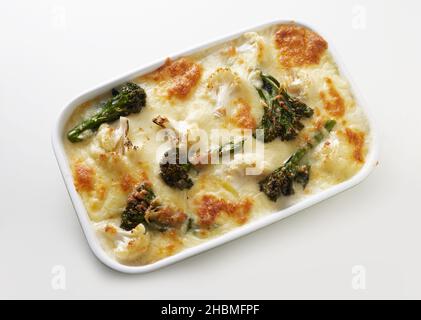 Top view of yummy baked traditional French dish made of broccoli and vegetables layered in casserole pan with cheese and served on white background Stock Photo