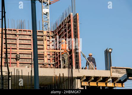 Construction of a high-rise building. Workers prepare formwork for pouring concrete. Stock Photo