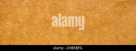 Bright orange colored Dotted Nepalese Lokta Paper features an embossed polka dot pattern which is then sun-washed on paper handmade in Nepal, abstract Stock Photo