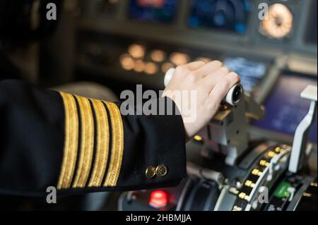 Female pilot's hand on the plane engine control stick. Stock Photo