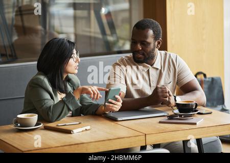 Portrait of two business people meeting at cafe table and discussing work, copy space Stock Photo