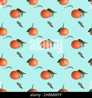 Tangerines seamless pattern with green leaves on light blue background Stock Photo