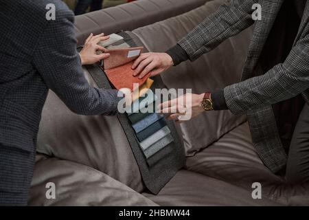 Two customers examining swatches in furniture shop Stock Photo