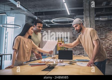 Girl and two guys discussing project Stock Photo