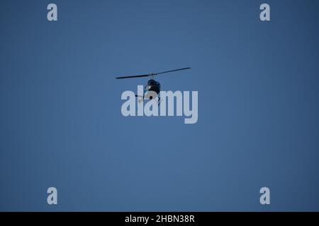 Frontal view of dark blue helicopter approach in flight. Stock Photo