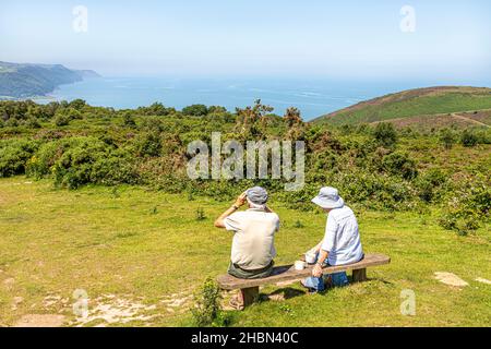 An older couple enjoying the view of the North Somerset coast from the viewpoint of Selworthy Beacon on Bossington Hill near Minehead, Somerset UK Stock Photo