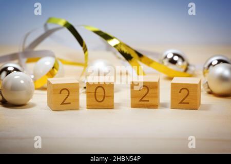 Wooden number cubes showing the new year 2022, Christmas decoration against a blue background, copy space, selected focus, narrow depth of field Stock Photo