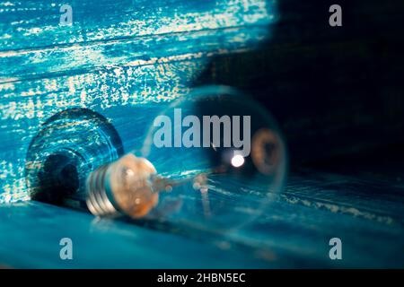 Close-up photo of the shadow left by a light bulb on a blurred blue wooden background; copy space Stock Photo