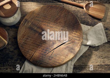 round wooden cutting board on rustic kitchen table, top view Stock Photo