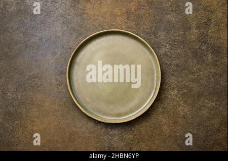 Top view empty green ceramic plate on brown rustic background, copy space Stock Photo