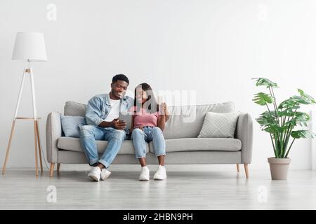 Black couple using pc and debit credit card at home Stock Photo