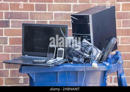 Old computer hardware and mobile devices put into a recycling container. High quality photo Stock Photo