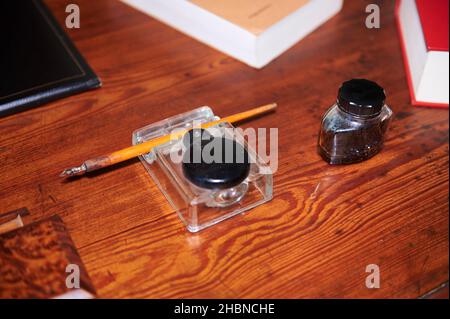 Ancient quill pen and ink bottle on the desktop Stock Photo