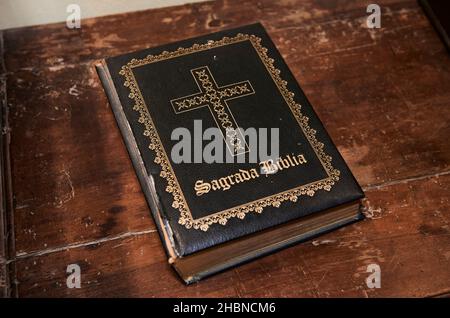 Much used book of the holy bible on wooden desk Stock Photo