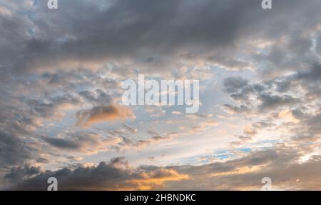 Evening sky with some yellow, white, grey and dark clouds Stock Photo