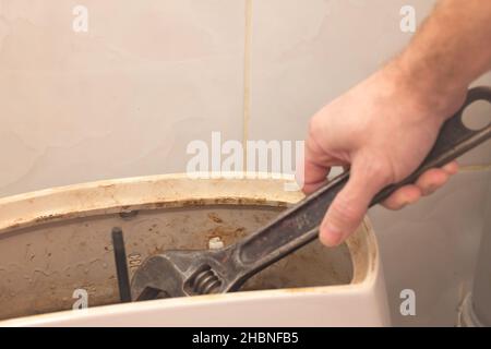 A man performs in a toilet flush tank. Stock Photo