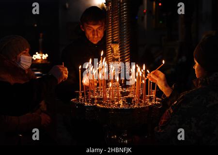 Sviatohirsk, Ukraine. 19th Dec, 2021. Believers seen placing burning candles in Assumption Cathedral.The Holy Assumption Sviatohirsk Lavra is an important spiritual center of eastern Ukraine. This Orthodox monastery is located on the right high chalk bank of the Siverskyi Donets River (on the so-called Holy Mountains) within the town of Sviatohirsk in the north of the Donetsk region. Credit: SOPA Images Limited/Alamy Live News Stock Photo