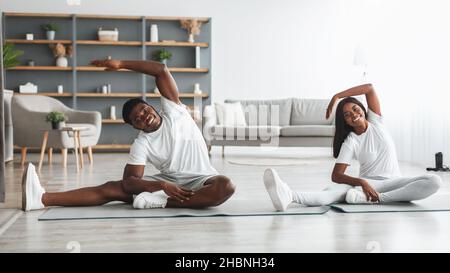 Young black couple doing side bend exercise together Stock Photo