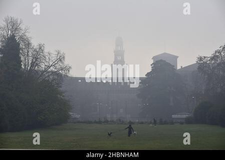 Milan, Lombardy, Italy. 19th Dec, 2021. December 19, Milan, Lombardy, Italy: A woman, with her two dogs in the Sempione park, during the thick fog, early in the morning Credit: Ervin Shulku/ZUMA Wire/Alamy Live News Stock Photo