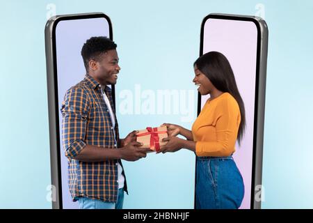Couple exchanging presents from cell phone screens Stock Photo