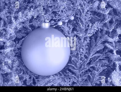 Bauble with Christmas tree branches decoration violet very peri colored background Stock Photo