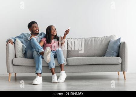 Young black woman switching on air conditioning at home Stock Photo
