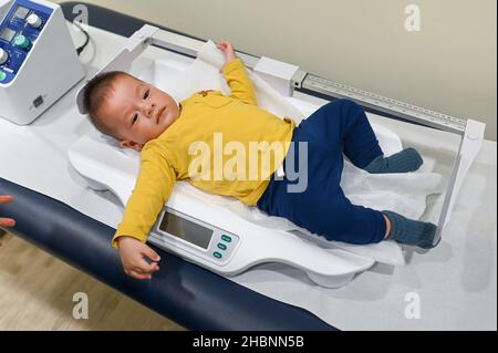 https://l450v.alamy.com/450v/2hbnn5b/5-months-old-mixed-race-baby-boy-on-a-weighting-scale-at-the-doctors-office-for-a-routine-checkup-and-physical-exam-to-track-progress-at-the-hospital-2hbnn5b.jpg