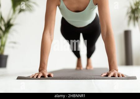 Cropped Shot Of Young Woman Making Push Ups On Fitness Mat Indoors Stock Photo