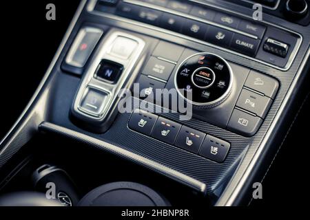 Close up shot of a modern car drive mode selector button, on the central console. Stock Photo