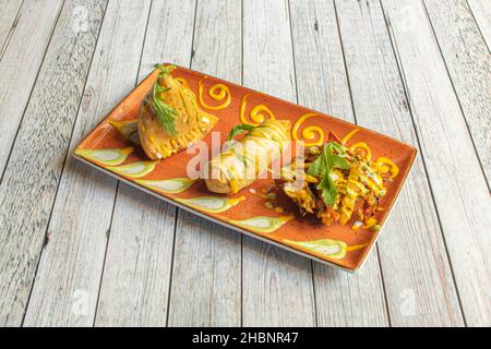 Samosa is a deep-fried dumpling with savory filling, spicy potatoes, onions, peas, meat, or lentils. It can take different shapes, triangular, conical Stock Photo