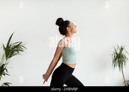 Smiling Fit Young Woman Warming Up Before Fitness Training, Stretching Arms Muscles Stock Photo