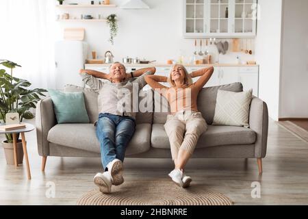Happy Senior Couple Relaxing Sitting On Sofa At Home Stock Photo